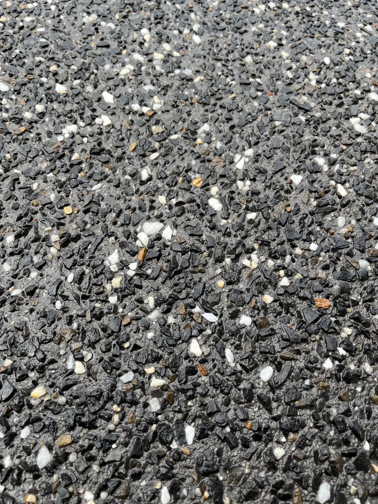 Dark exposed aggregate concrete close-up
