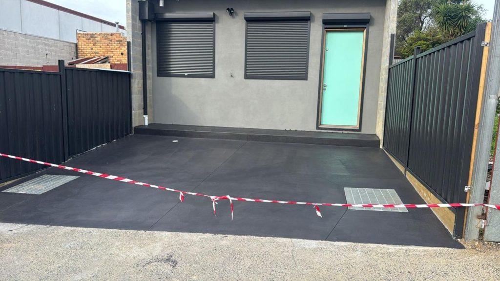 Charcoal coloured concrete driveway outside a modern Melbourne townhouse