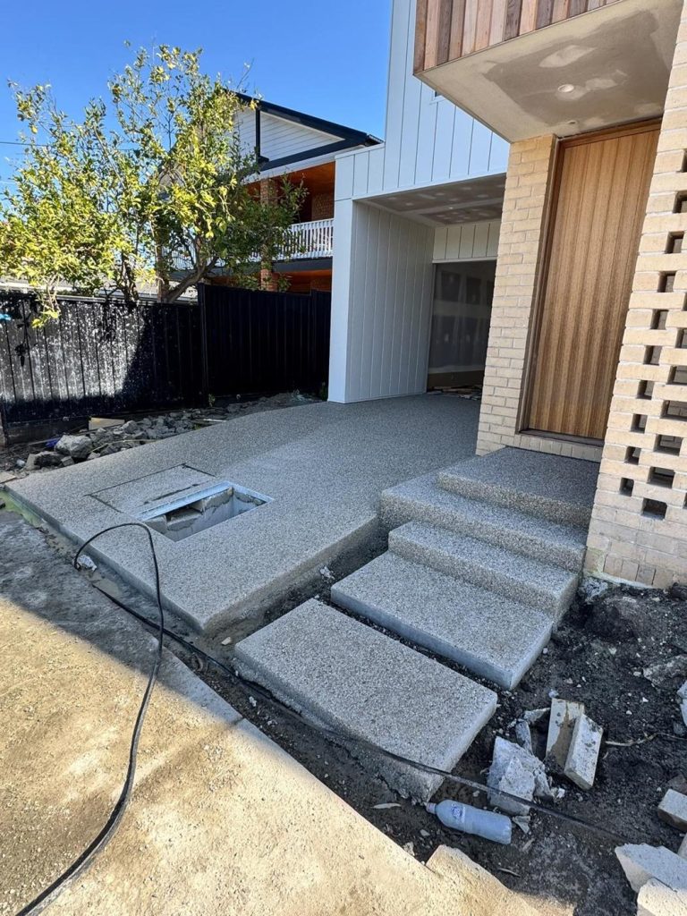 Exposed aggregate front porch and floating-style concrete steps at a new Melbourne home